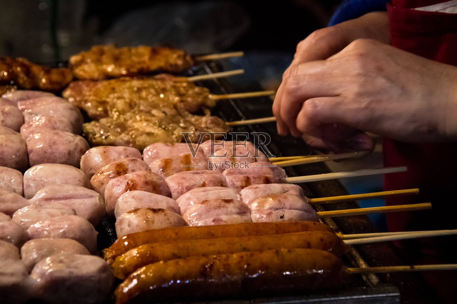 在热煤炉上烤的泰国香肠和猪肉串照片摄影图片