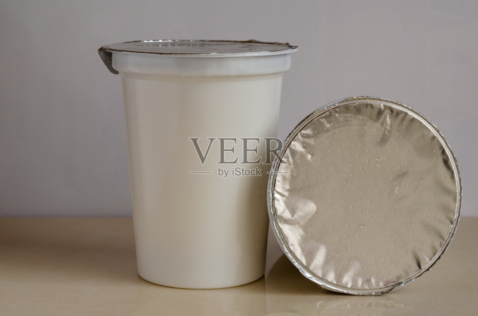 塑料容器和酸奶在一个较轻的背景。照片摄影图片