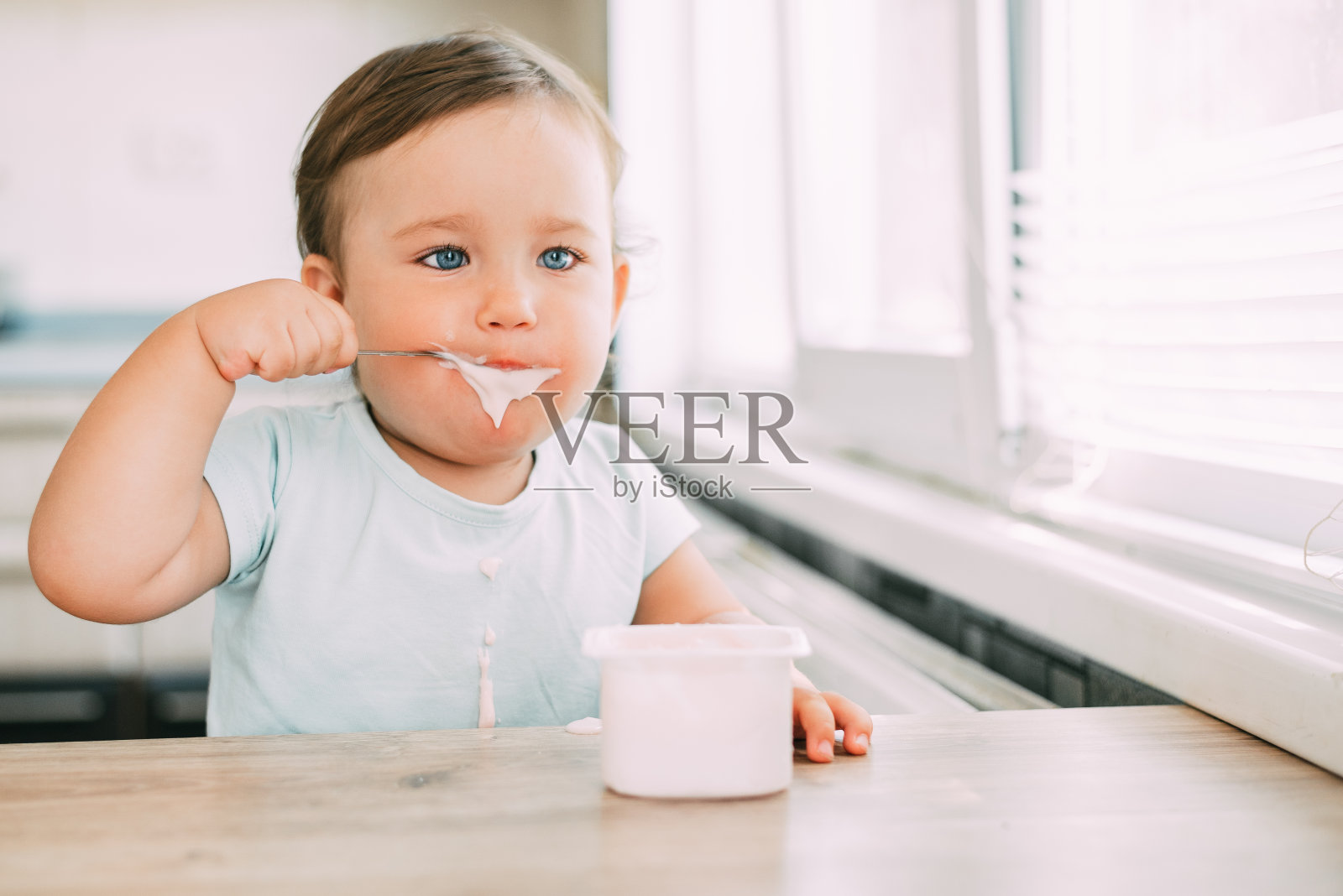 小女孩下午在厨房里吃酸奶照片摄影图片