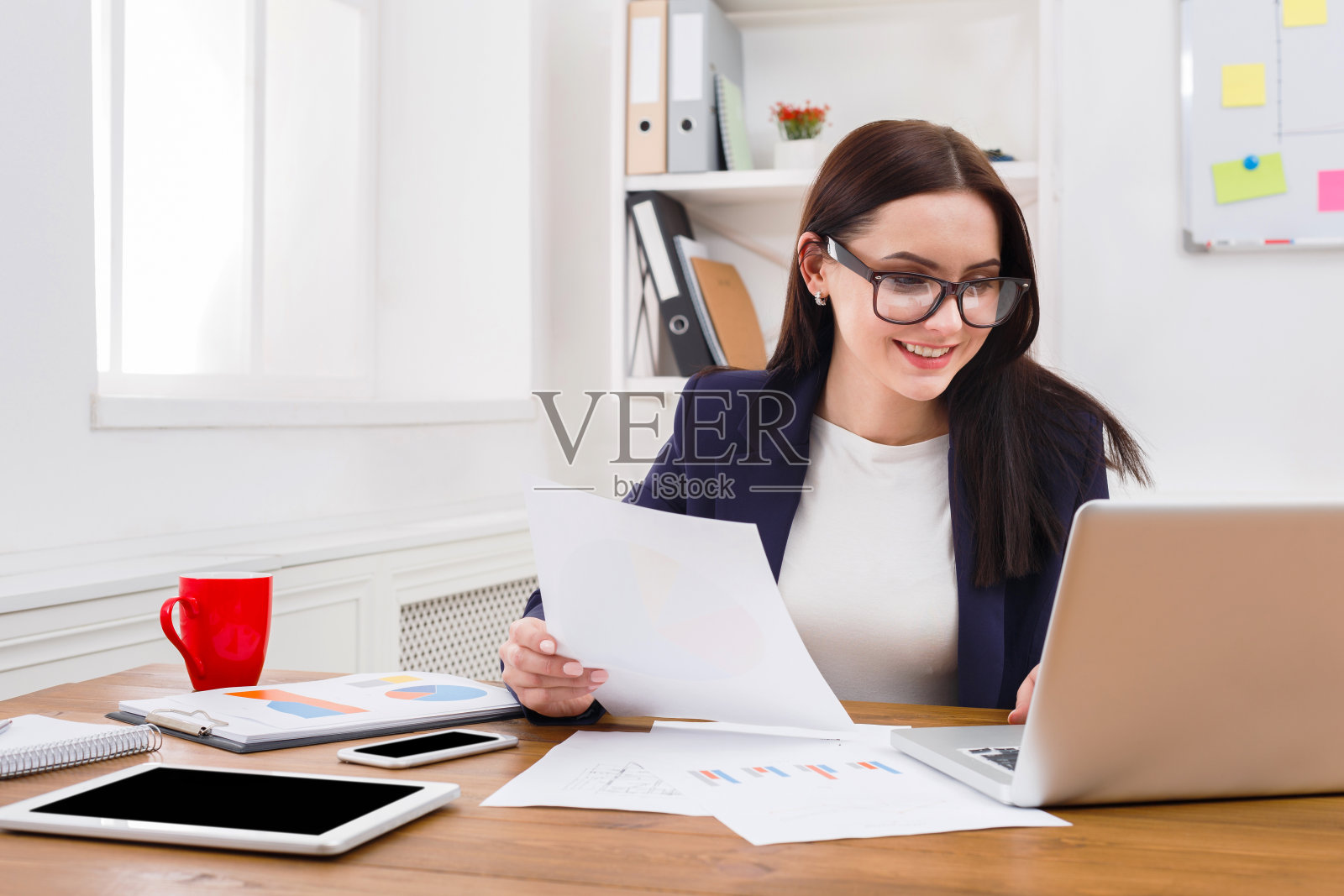 商务女性在办公桌前阅读文件照片摄影图片