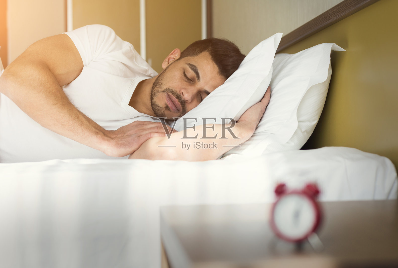 侧视图英俊的男人睡在床上照片摄影图片