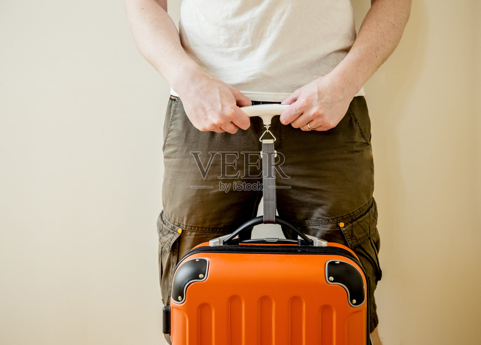 男子游客在家里使用数字行李秤称重行李，以避免超重行李在机场的概念。减少旅行的压力。照片摄影图片