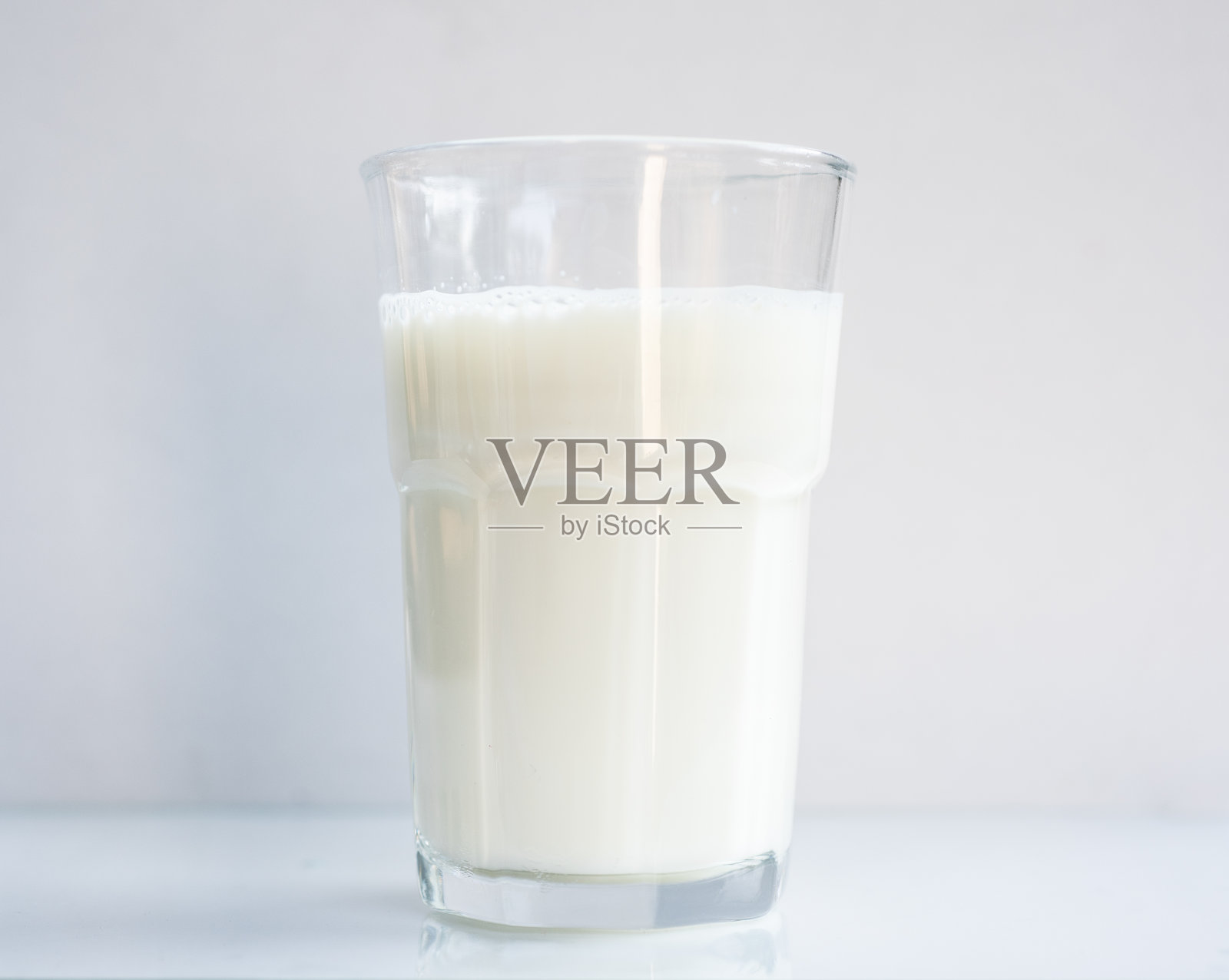 一杯牛奶在白色的背景上饮用的概念。照片摄影图片