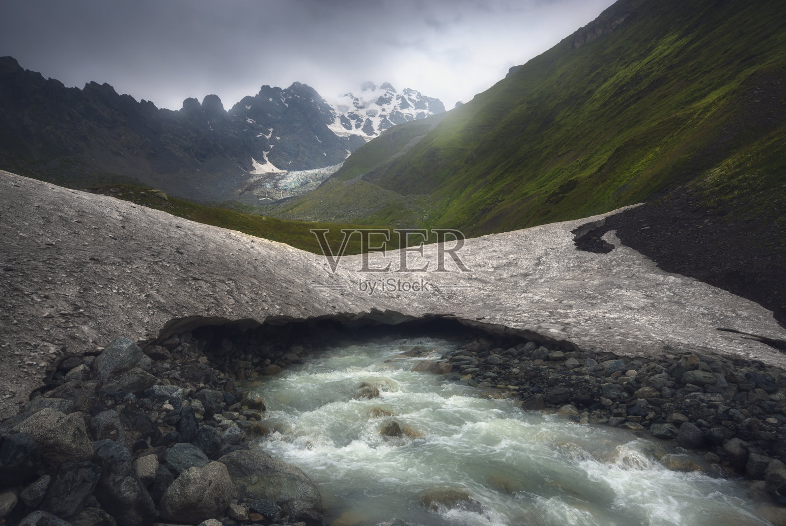 雨后湍急的山河在古老的冰川下流淌照片摄影图片