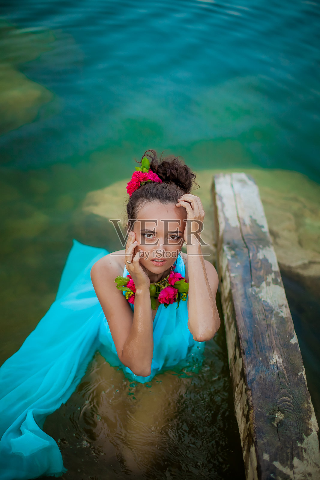 女模特在蓝色的衣服和舞台化妆摆姿势在水照片摄影图片
