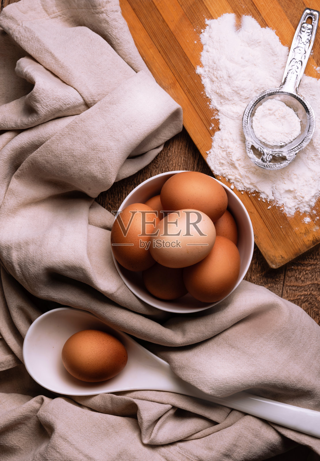 在厨房的桌子上烤鸡蛋和面粉。照片摄影图片