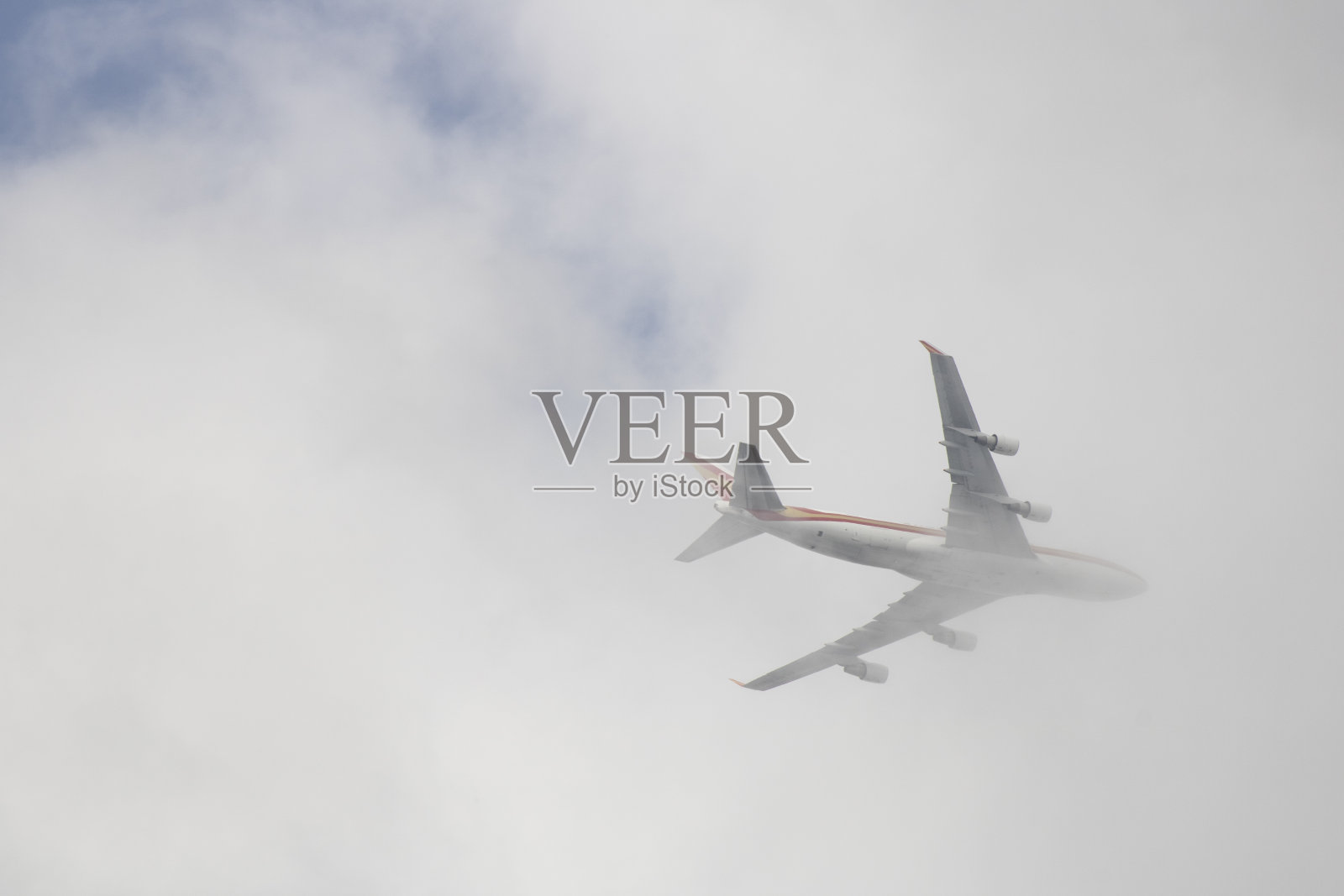 在天空中进入云层的飞机。照片摄影图片