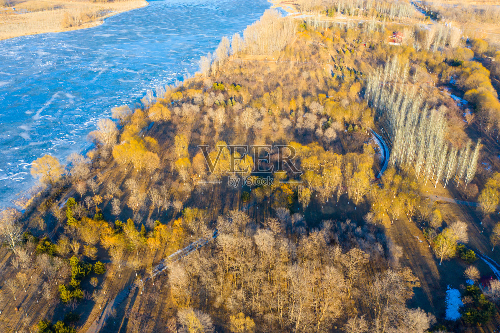 无人机在冬天俯瞰森林和河流，太阳的阴影照片摄影图片