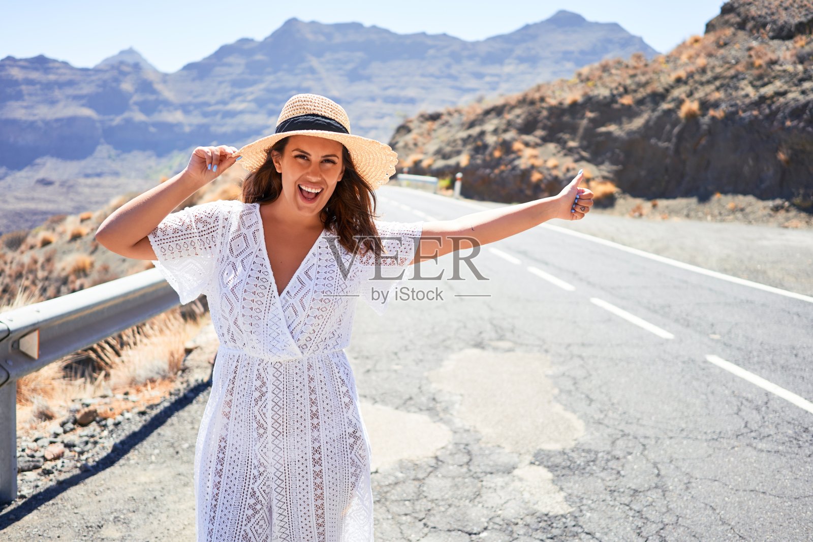 搭顺风车的女人搭顺风车在路边旅行，开心地笑着过暑假照片摄影图片