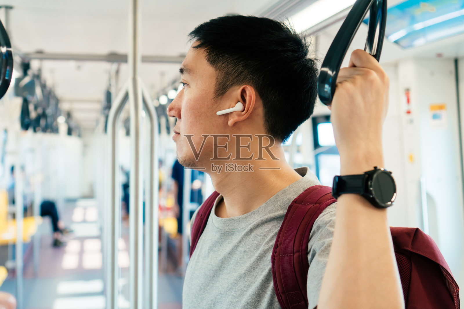 近距离的年轻人听音乐与无线耳机，而乘火车上下班。喜欢边走边听音乐的亚洲人照片摄影图片