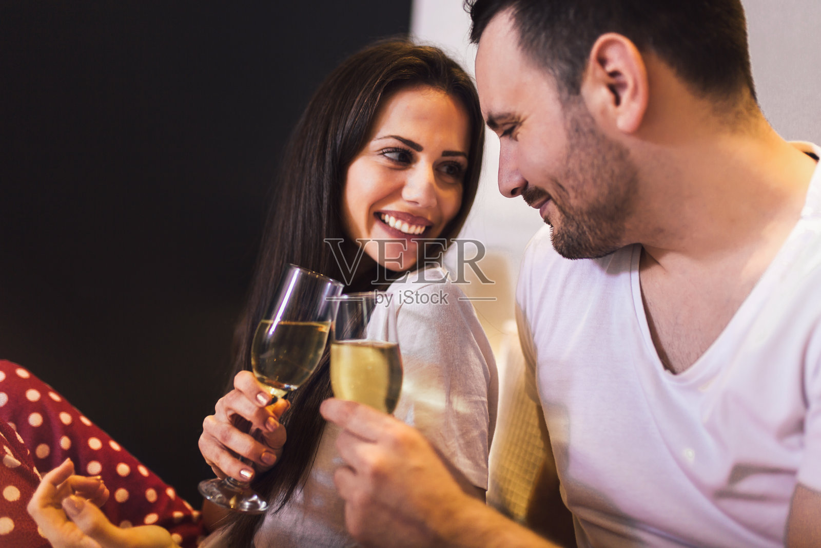 年轻夫妇男女在床上亲密地喝着香槟照片摄影图片