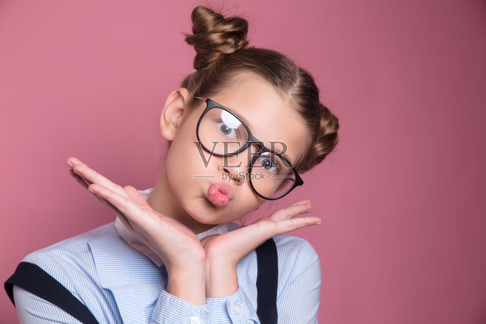 一个年轻的女学生的特写肖像与眼镜有乐趣的粉红色的背景照片摄影图片