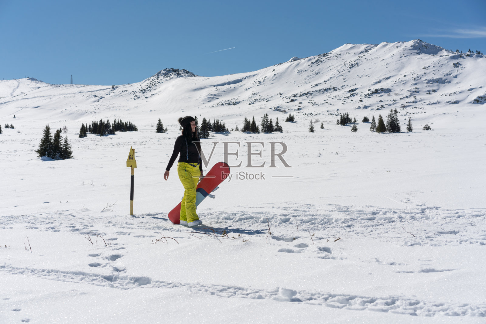 在山上行走的女子单板滑雪运动员照片摄影图片