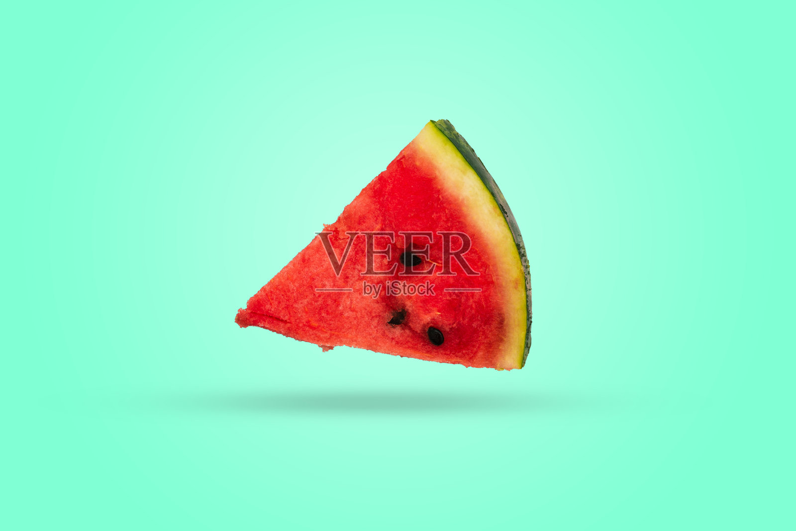 三角形西瓜在彩色背景上呈三角形的一块西瓜熟透的鲜西瓜片，红瓤绿皮。照片摄影图片