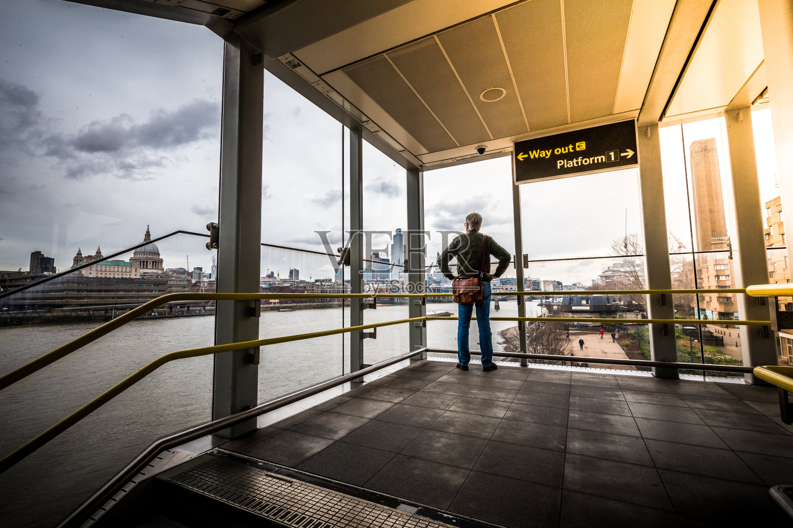 透过窗户眺望现代伦敦城市天际线的上班族照片摄影图片