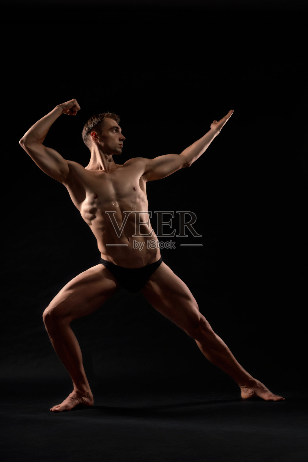 男性健美运动员展示比赛姿势。照片摄影图片