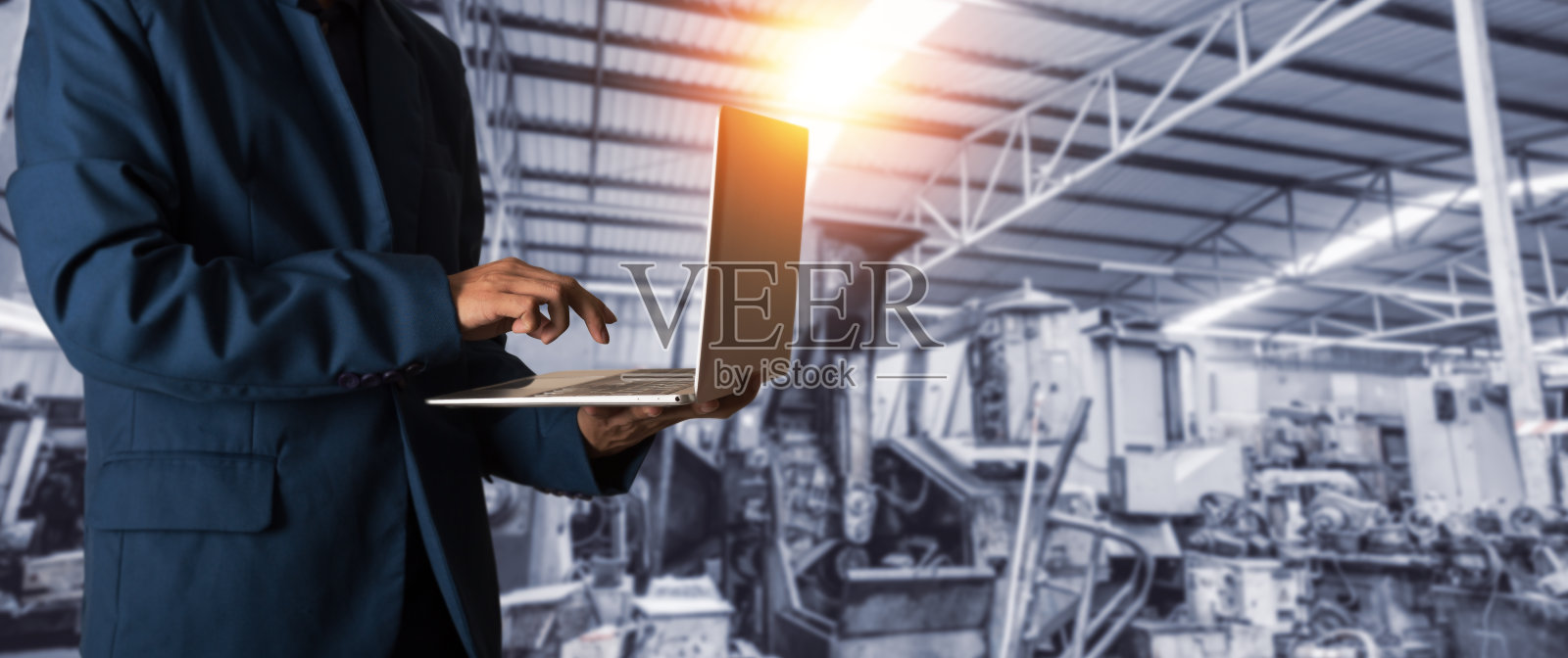 经理在西装中工业工程师使用笔记本电脑与背景工业制造工厂在各种金属制品照片摄影图片