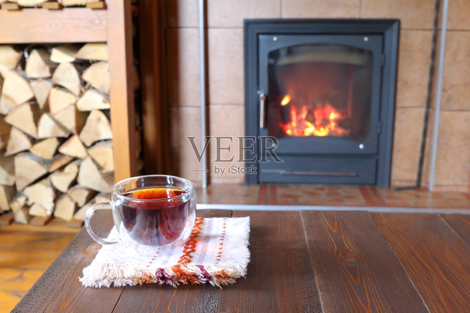 在一间小木屋的壁炉边喝杯茶。照片摄影图片