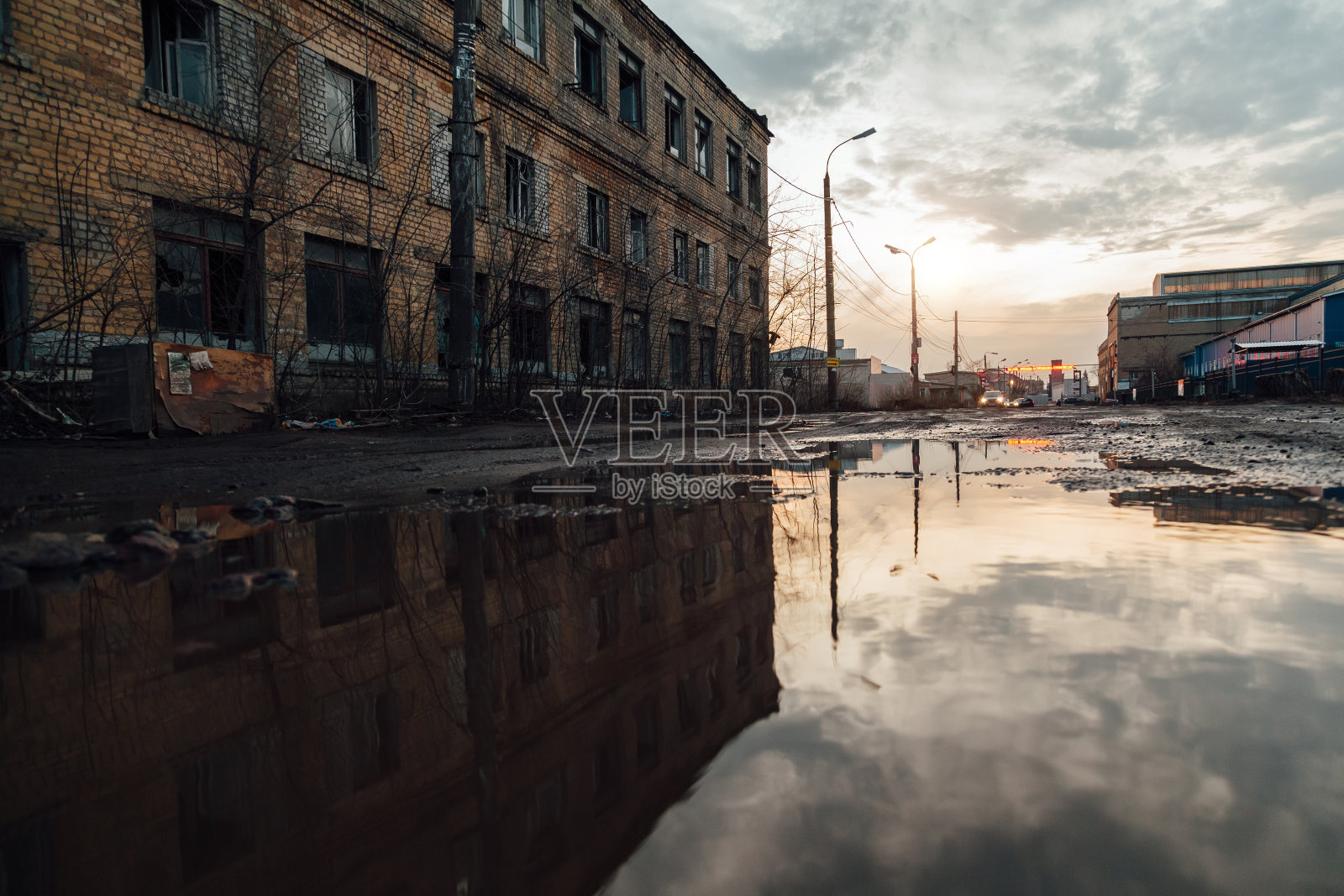废弃的工业建筑反射在雨水池中照片摄影图片