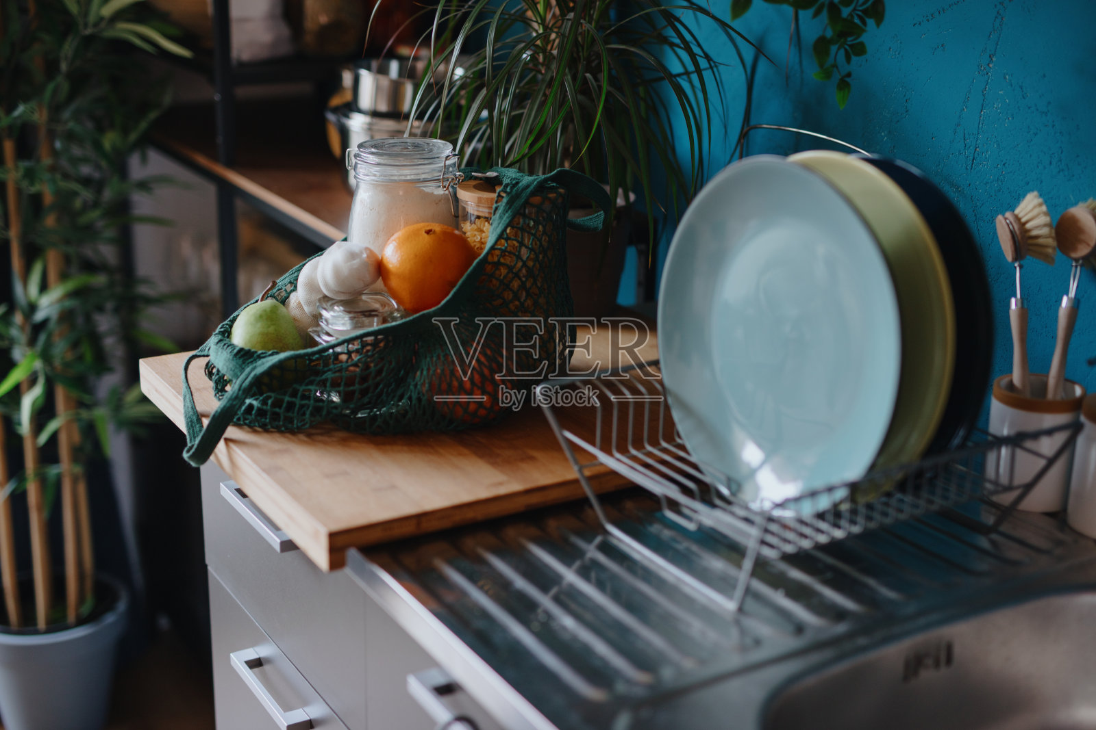 厨房柜台上的环保袋，装着罐装食品和新鲜水果。“零浪费”的概念照片摄影图片