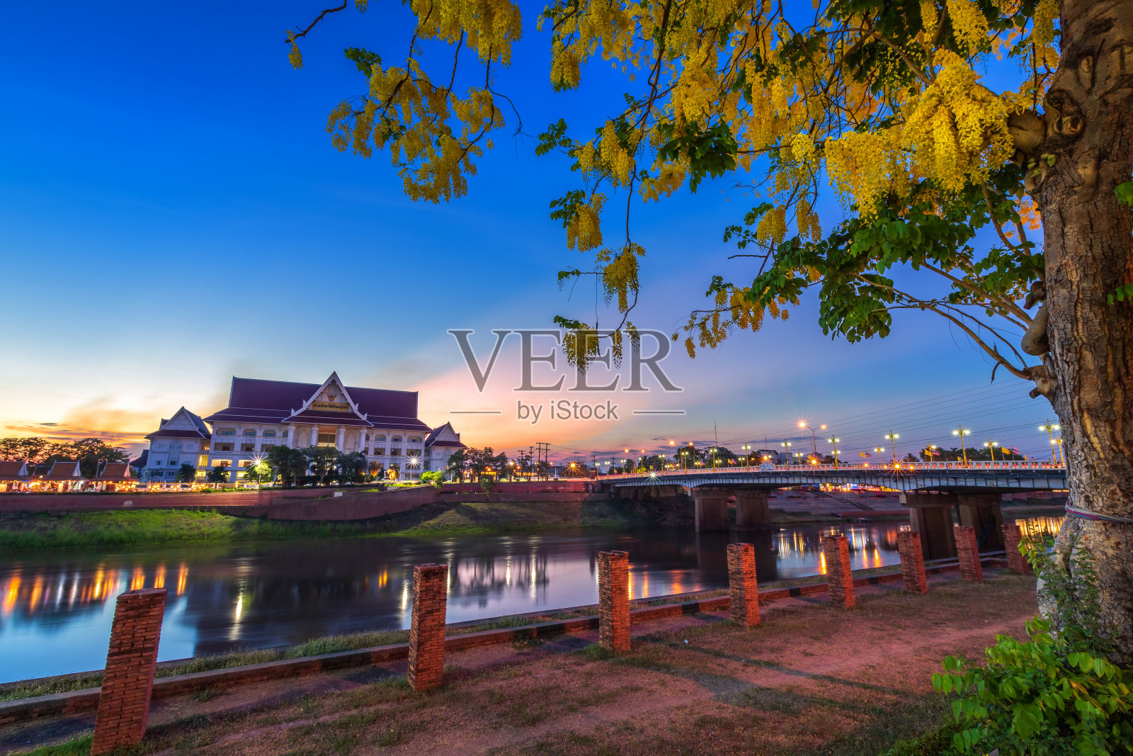 傍晚，在彭世洛市的公园里，欣赏南河(泰国语:彭世洛省法院)和纳雷苏大桥，在日落时分放松地散步和慢跑照片摄影图片