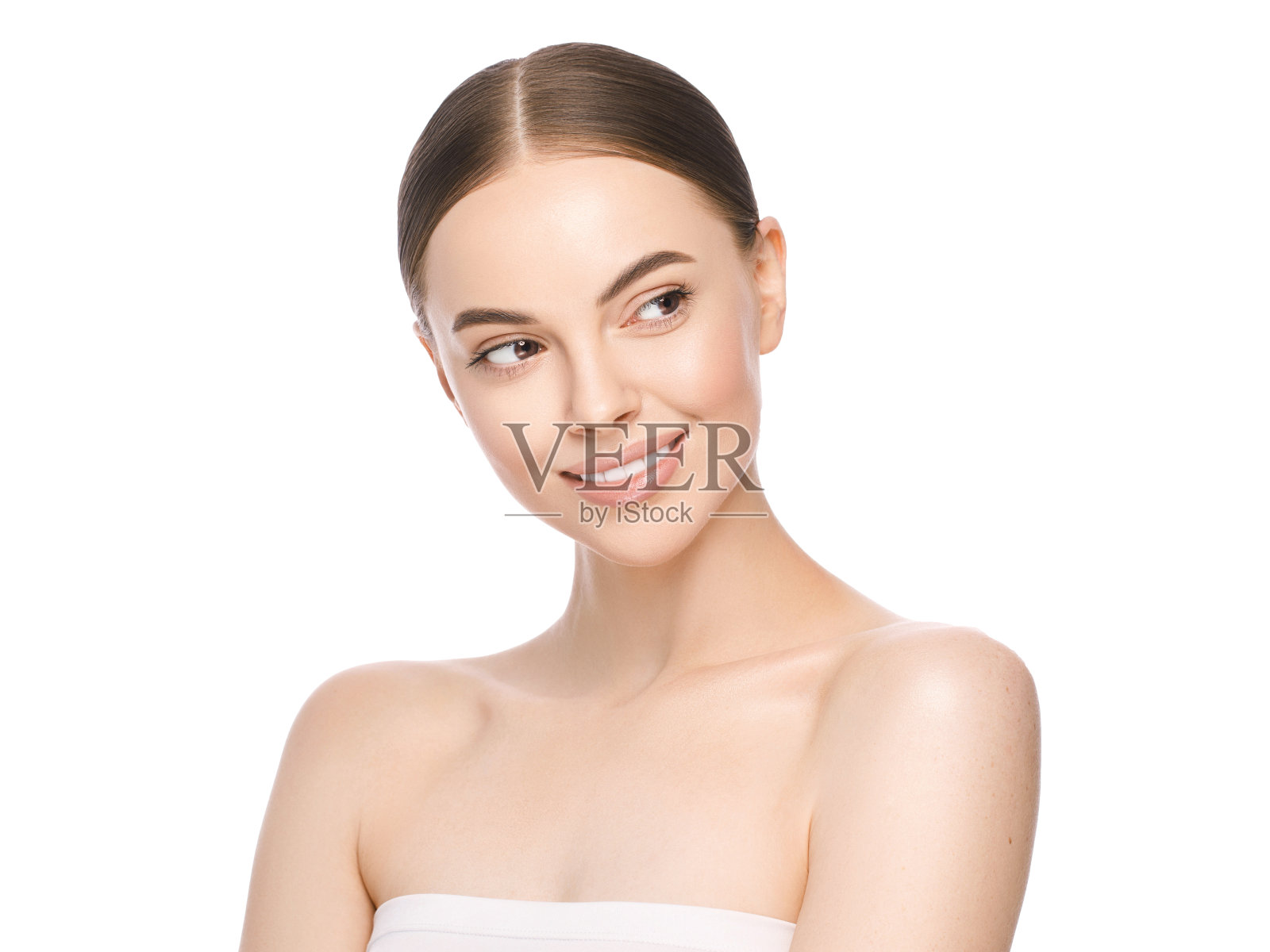 美丽的女人的脸与棕色眼睛看一边，孤立在白色的背景。护肤治疗或化妆品广告概念。美丽的女性模特与完美的新鲜和干净的皮肤照片摄影图片