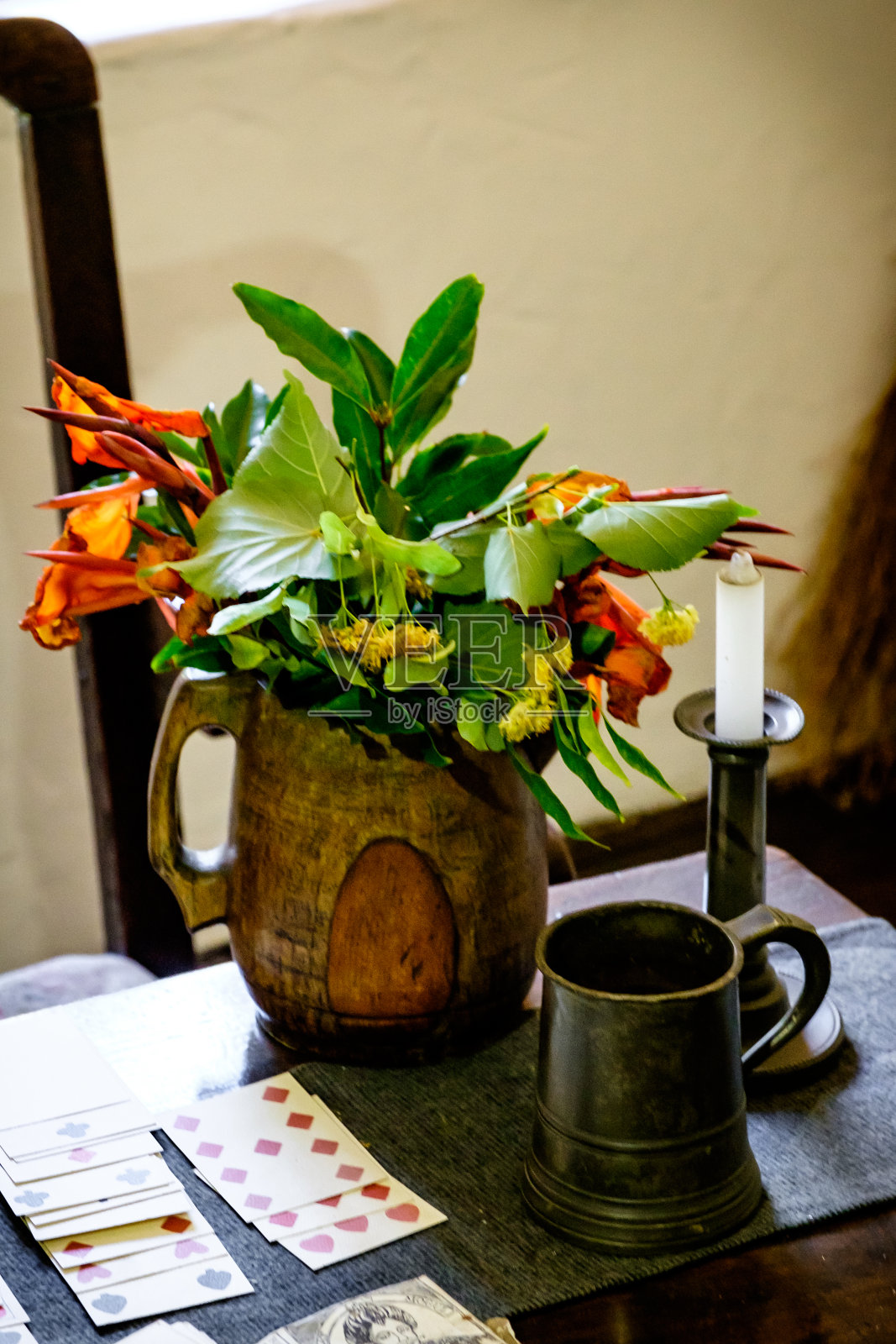 一张古老的桌子上摆放着花瓶和鲜花，青铜器皿和卡片照片摄影图片