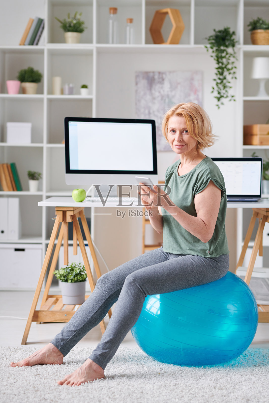相当成熟的女性用智能手机搜索在线健身课程照片摄影图片