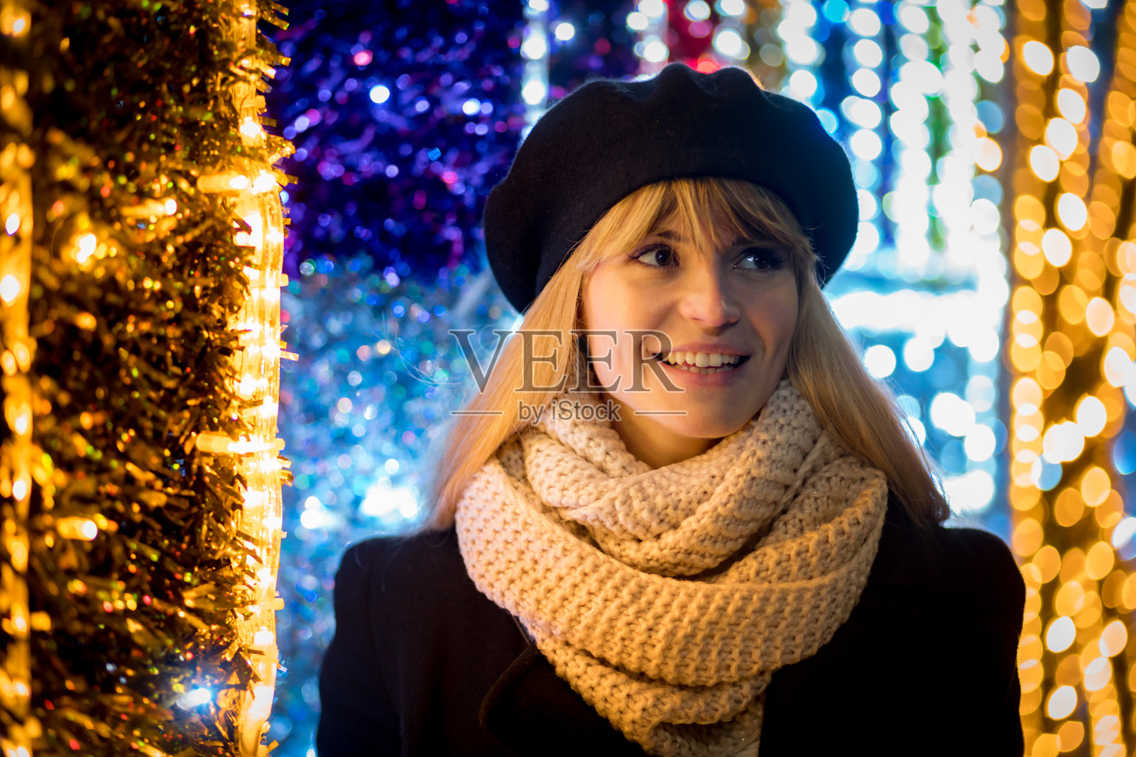 快乐微笑的女孩走在照亮的小巷在圣诞节照片摄影图片
