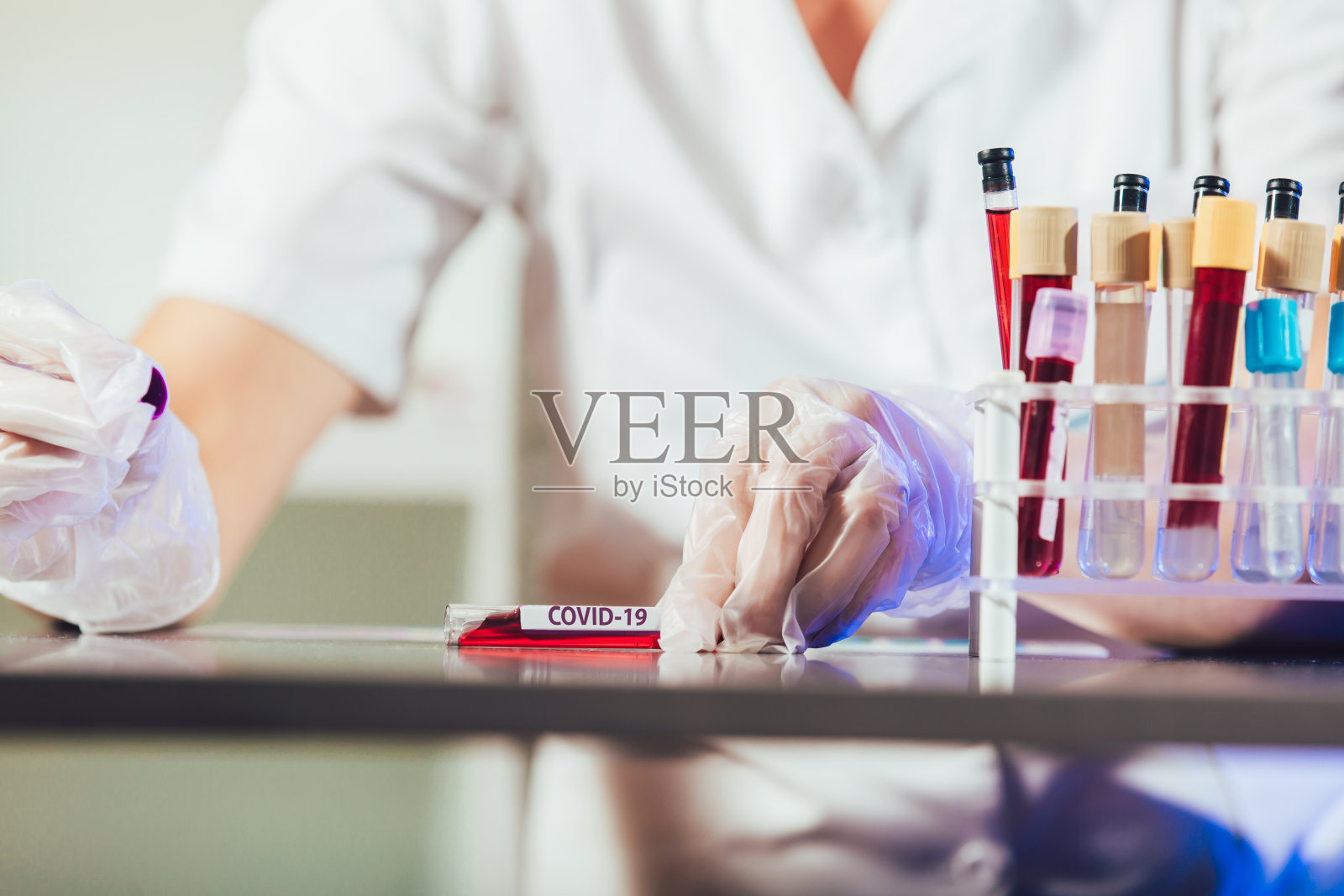 实验室技术员助理在实验室的试管中分析血液样本。照片摄影图片