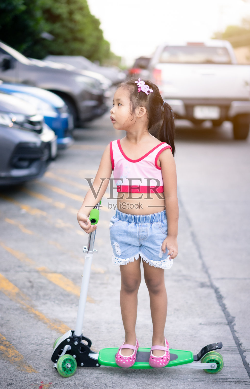 可爱的亚洲小女孩在街上玩滑板车照片摄影图片