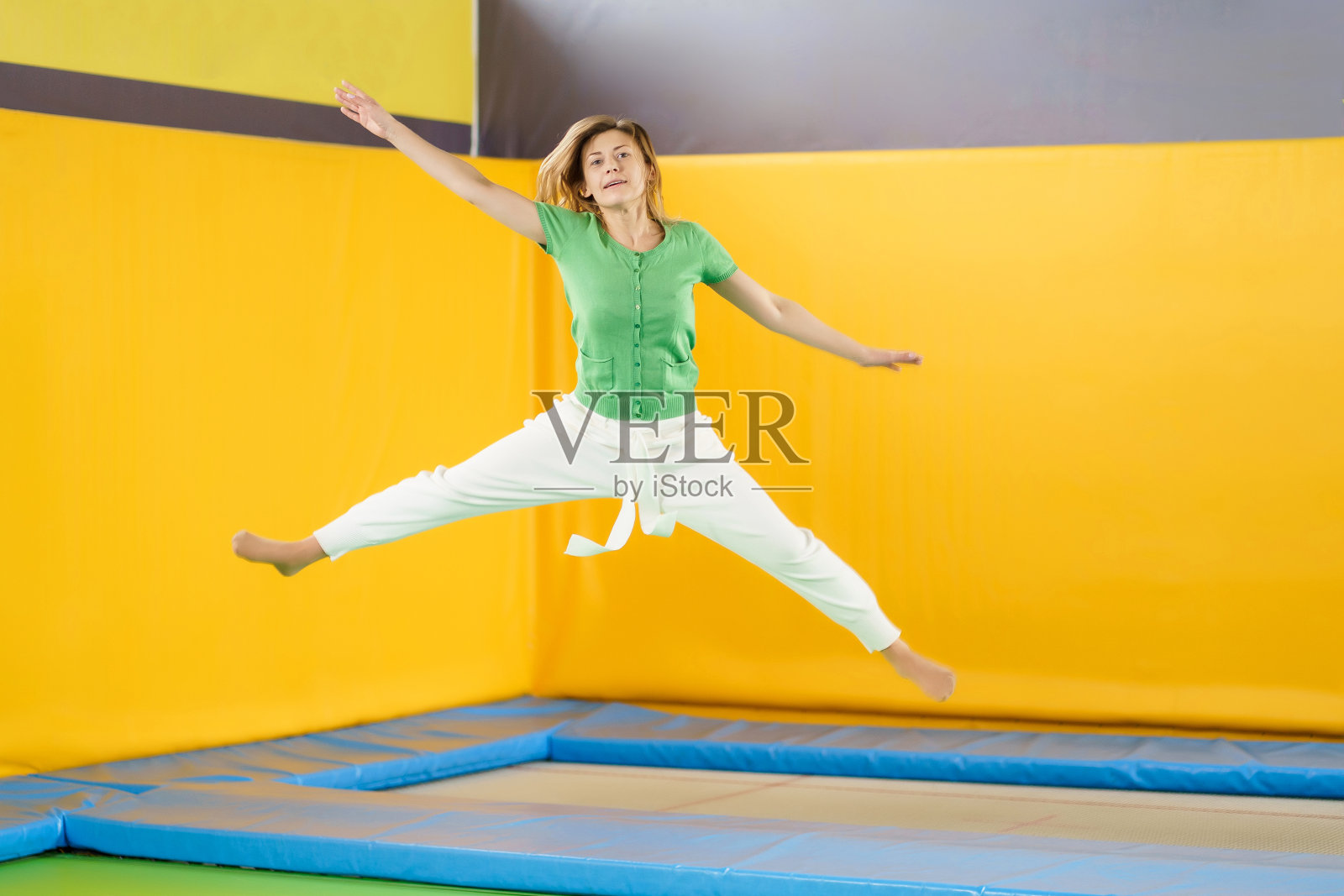 一个小女孩在运动中心的蹦床上跳照片摄影图片