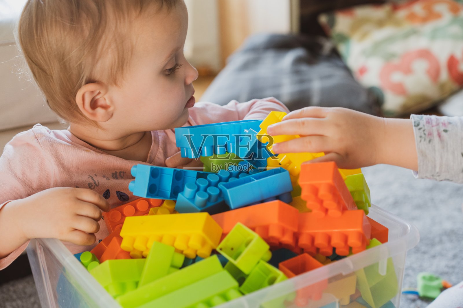 宝宝玩积木玩具。幼儿园的概念。婴儿在盒子里玩玩具。幼儿园的教育和玩耍。幼儿与老师玩耍。可爱的小女孩玩玩具。女孩在家里玩塑料木制玩具。照片摄影图片