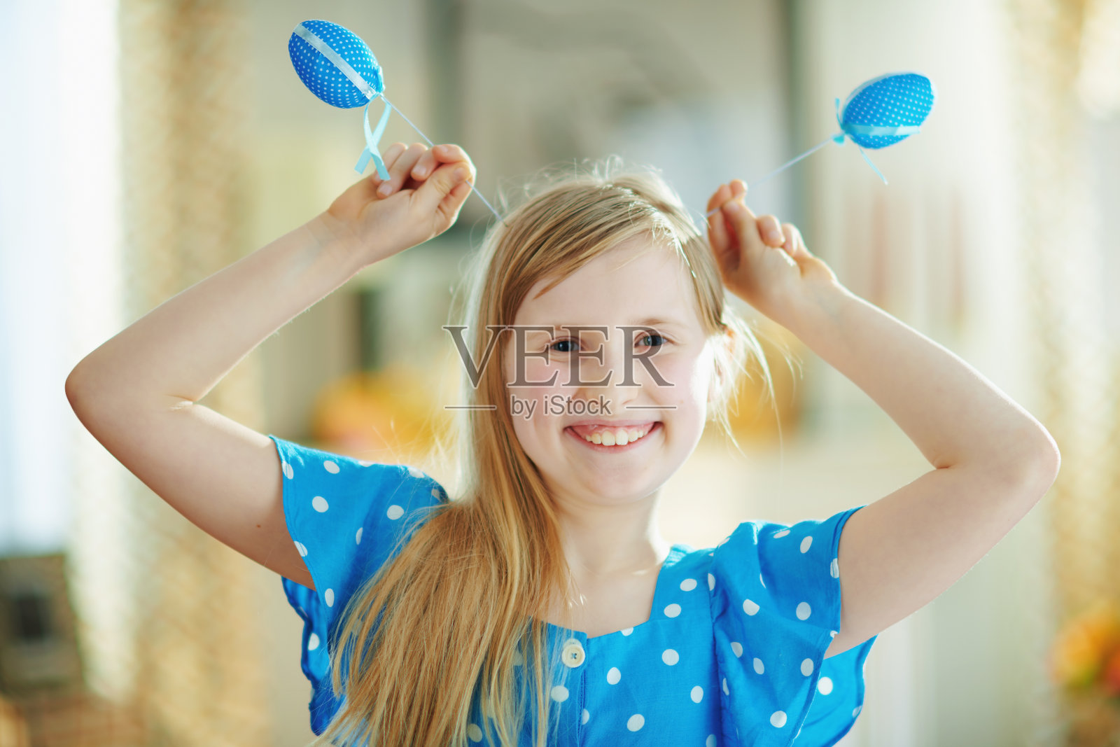 快乐的现代孩子用蓝色的复活节彩蛋做耳朵照片摄影图片