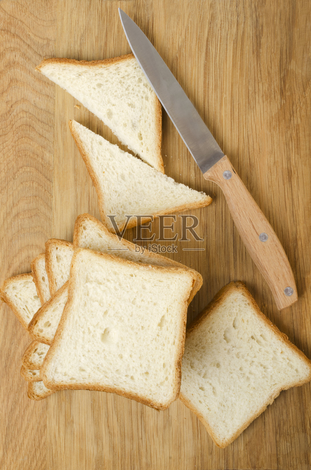 木制砧板的俯视图，烤面包用的白面包，放在上面。准备美味的烤面包片照片摄影图片