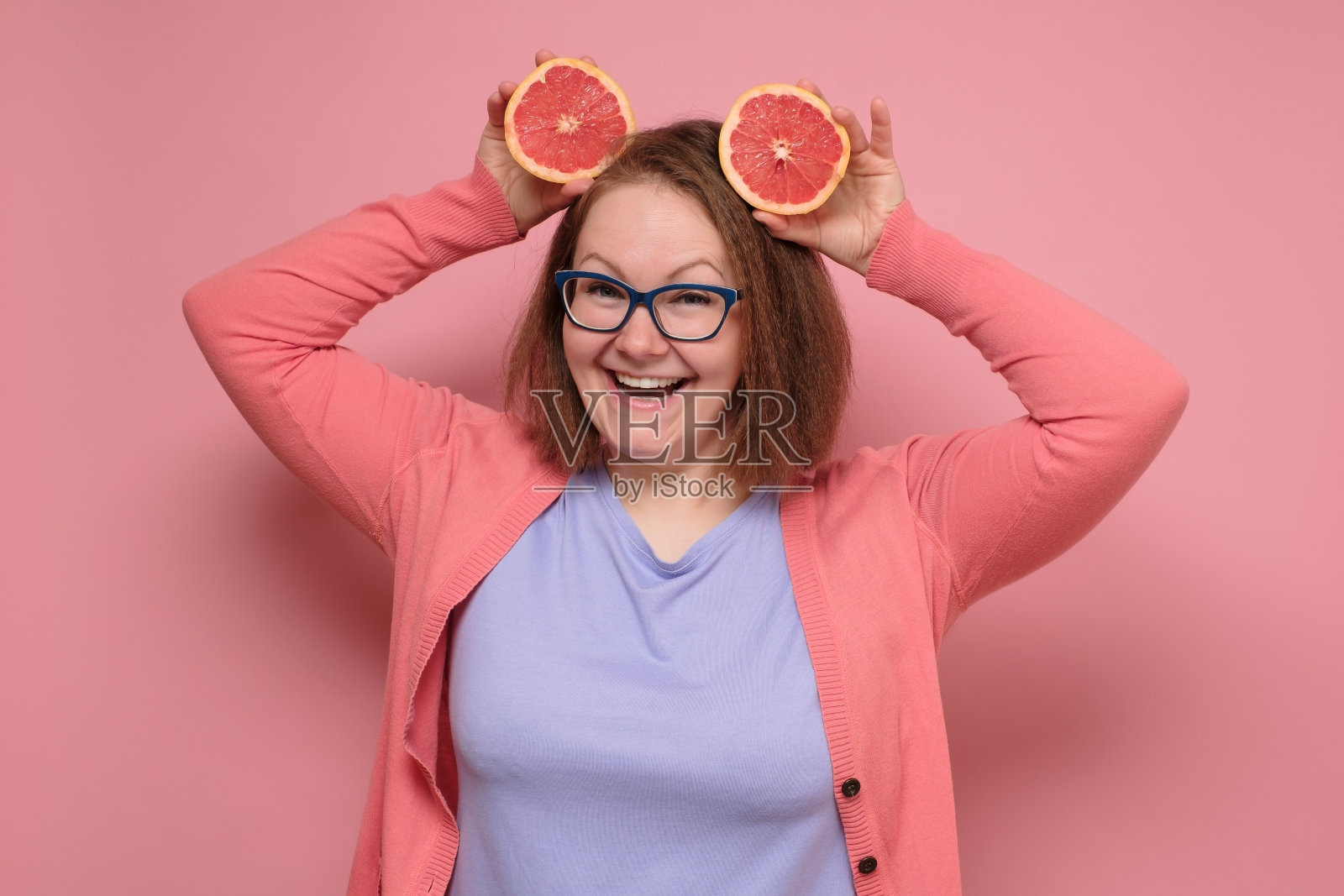 可爱的女孩拿着一片葡萄柚面带微笑照片摄影图片