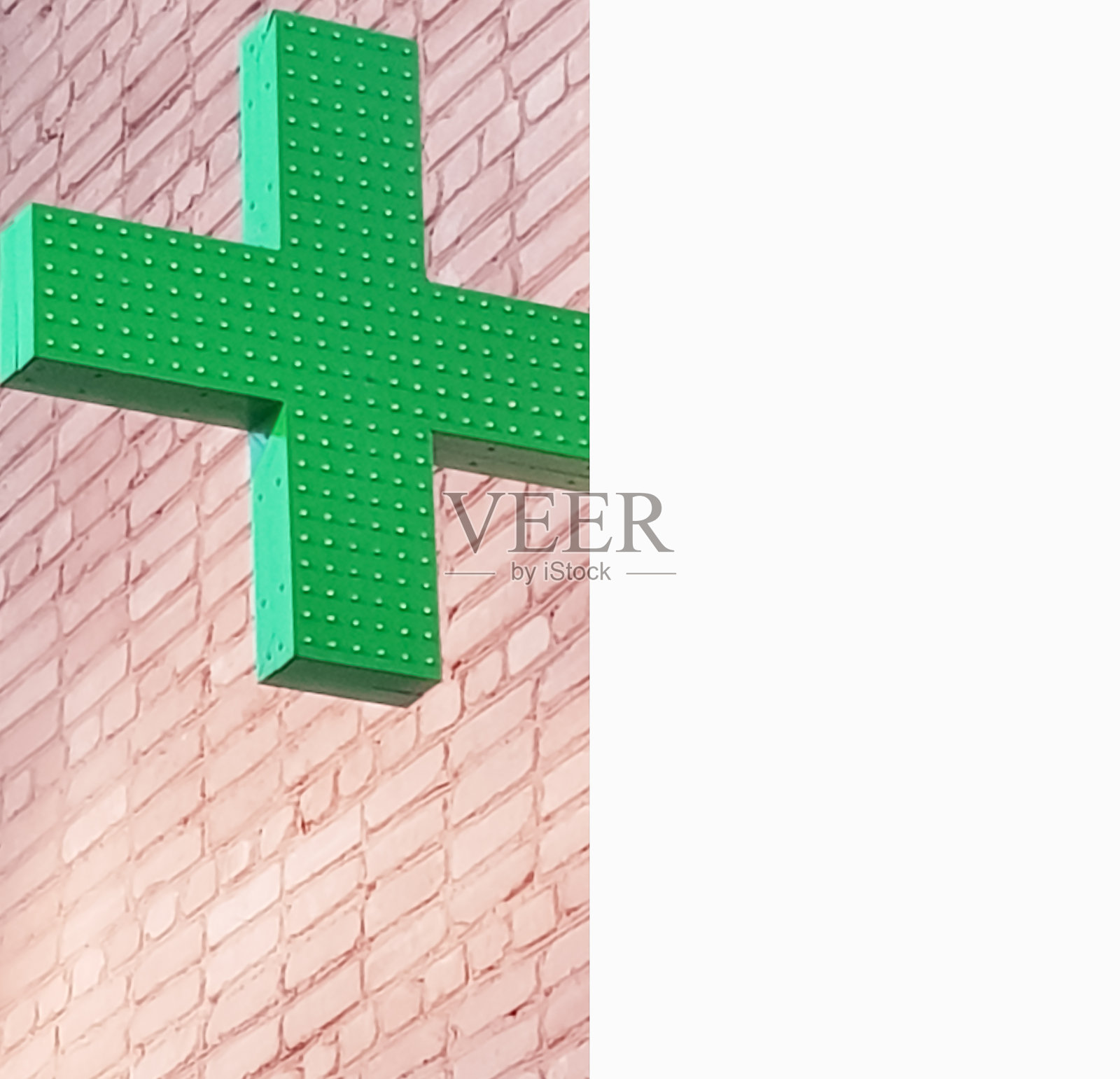 绿十字霓虹牌药店就在街边的一堵砖墙旁，概念医疗和治疗，复制空间照片摄影图片