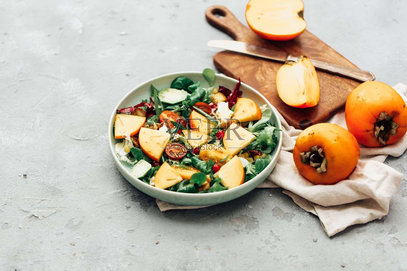 新鲜的沙拉与水果和绿色蔬菜在白色的木制背景近距离。健康食品。照片摄影图片