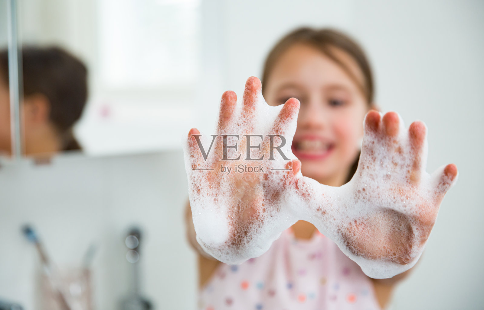 小女孩在浴室里用水和肥皂洗手照片摄影图片