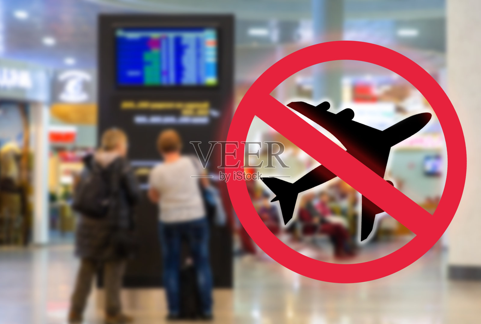 妇女们站在机场的问讯处。模糊。红色禁酒标志和一架飞机。禁止航班、关闭州边界和病毒大流行的概念照片摄影图片