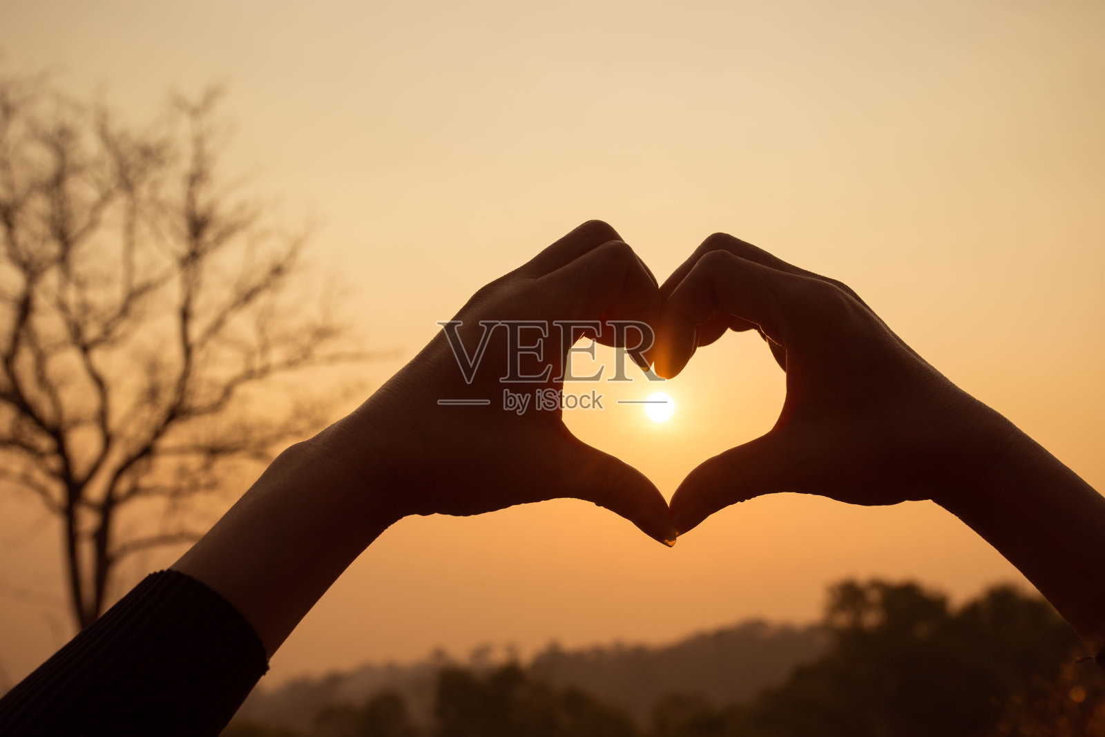 手做心形的爱与剪影在夕阳的背景照片摄影图片