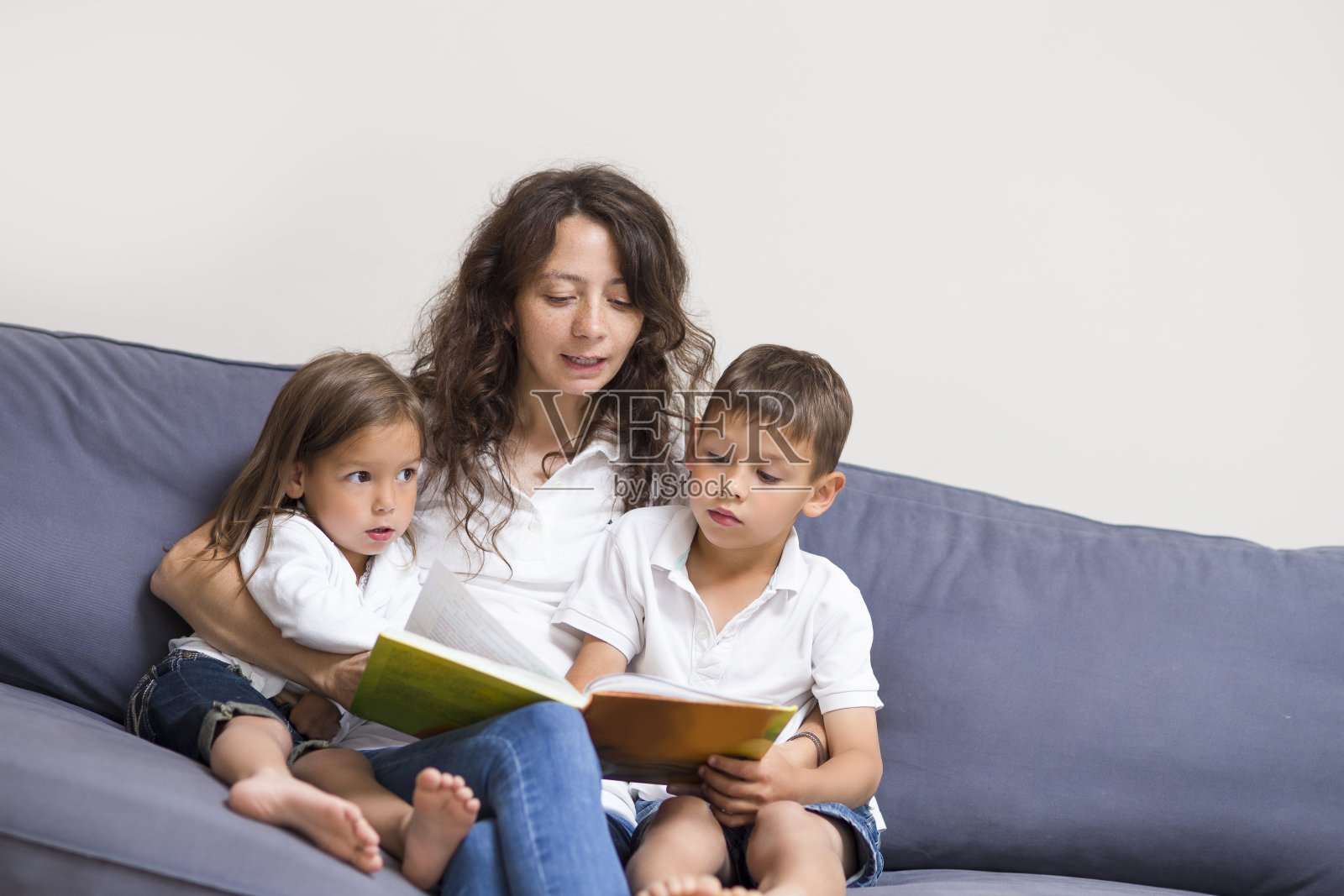 家庭关系的概念。妈妈和她的孩子们在室内看书。水平的形象照片摄影图片