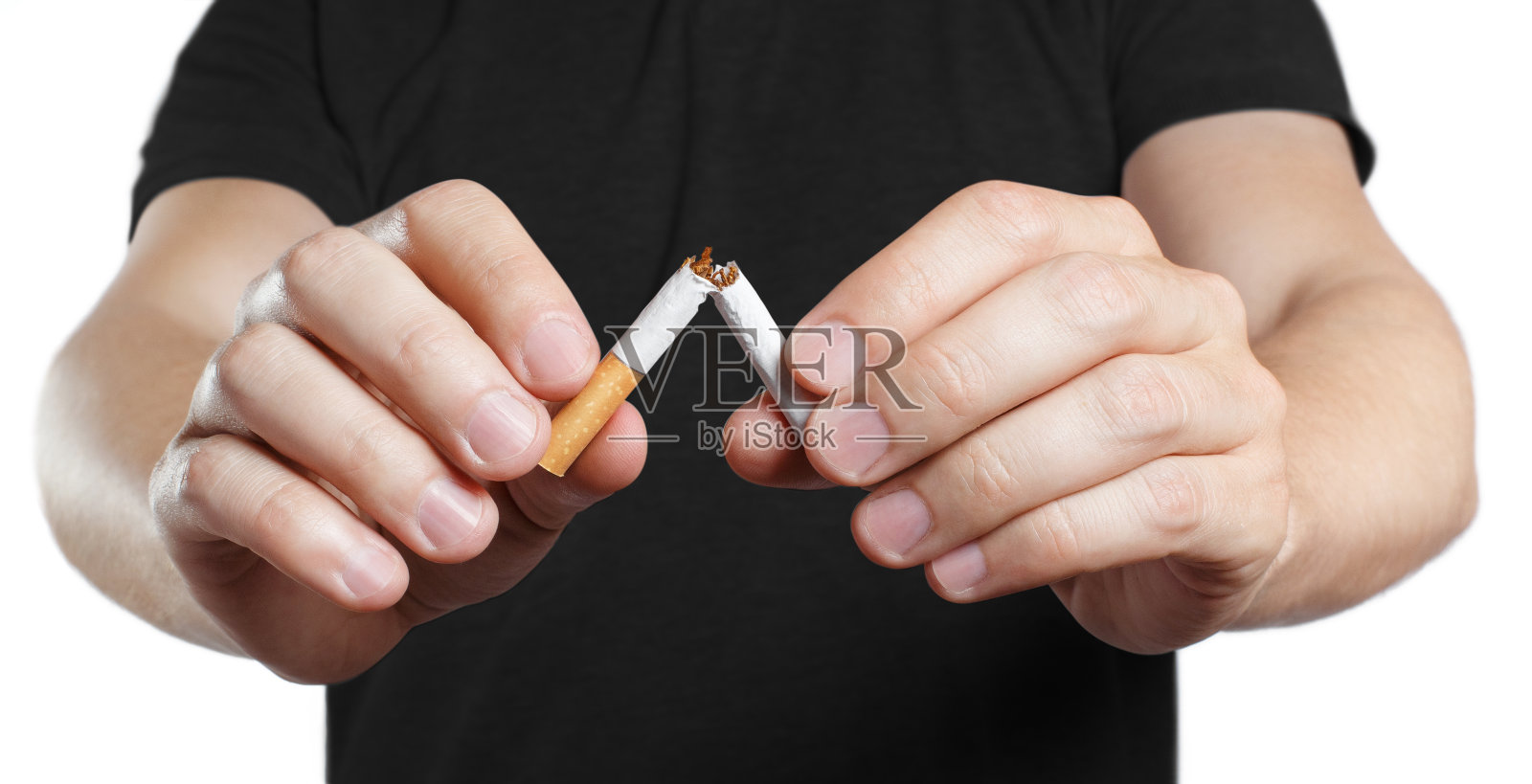 男性的手在白色上掰成两半的香烟照片摄影图片