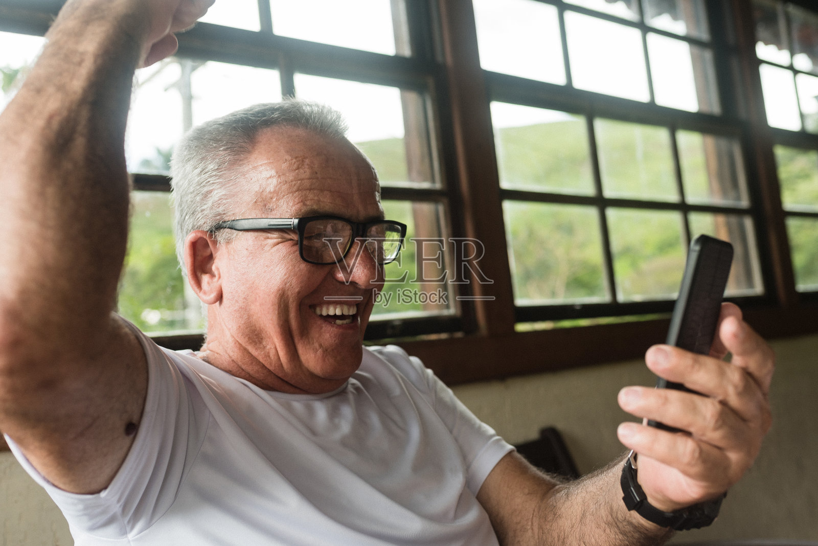 老男人在用智能手机看足球比赛照片摄影图片