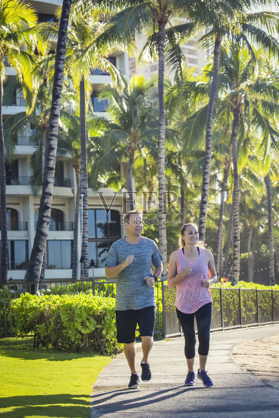 一对中年夫妇在热带海滩度假胜地一起慢跑照片摄影图片