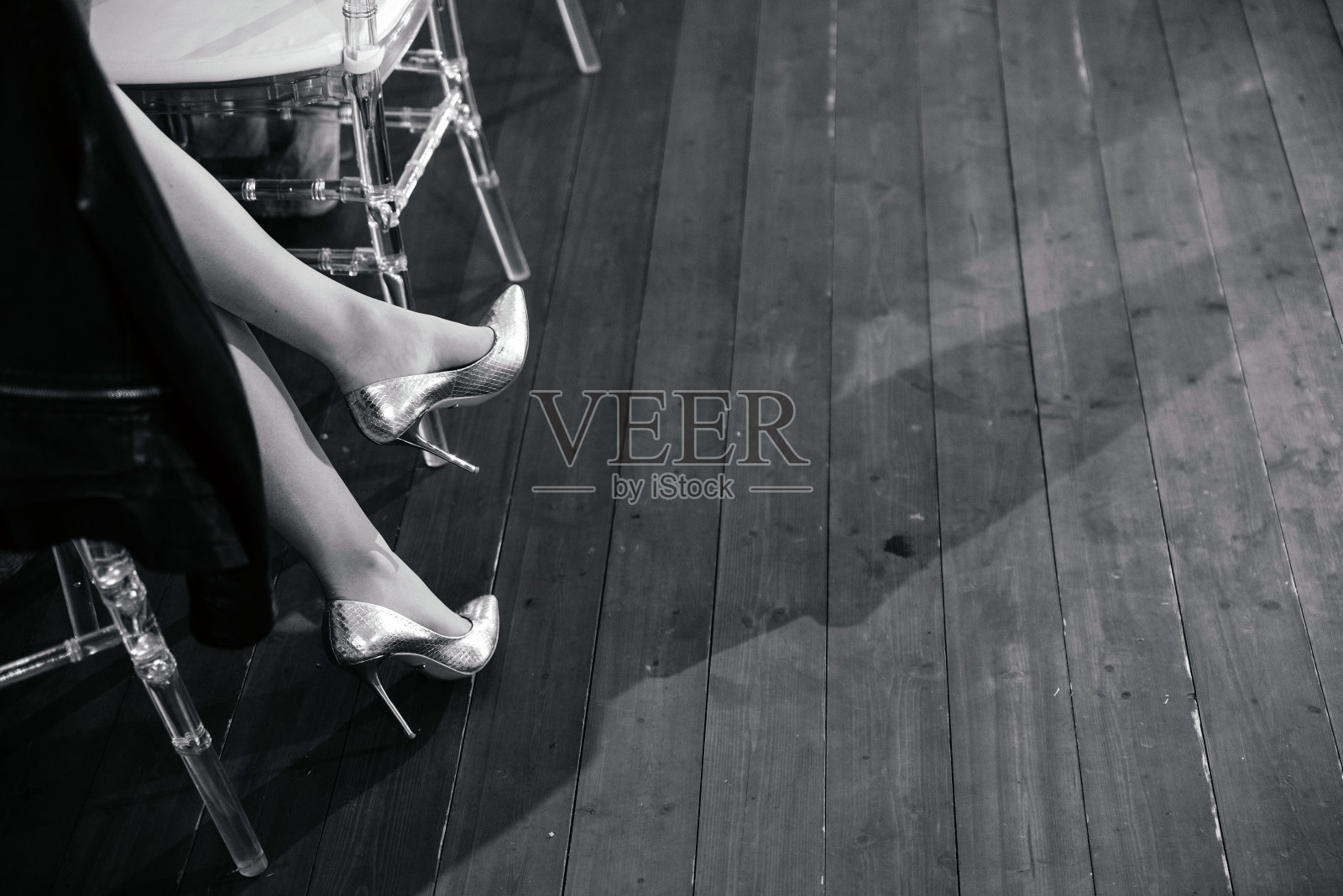 女人腿上穿着高跟鞋，女人坐在餐厅里等待约会，黑白相间，拷贝空间照片摄影图片