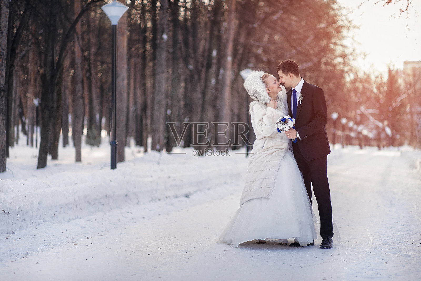 新娘和新郎在冬季公园散步照片摄影图片