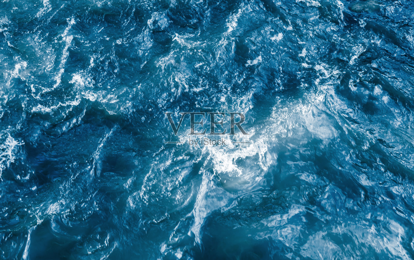 深蓝色的波涛汹涌的海水，溅起水花和泡沫照片摄影图片