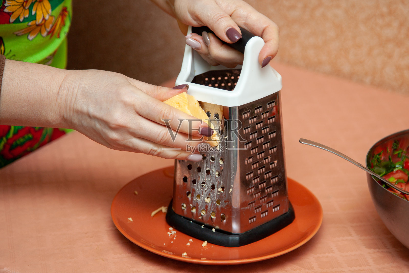 在家庭厨房的金属刨丝器上磨奶酪照片摄影图片