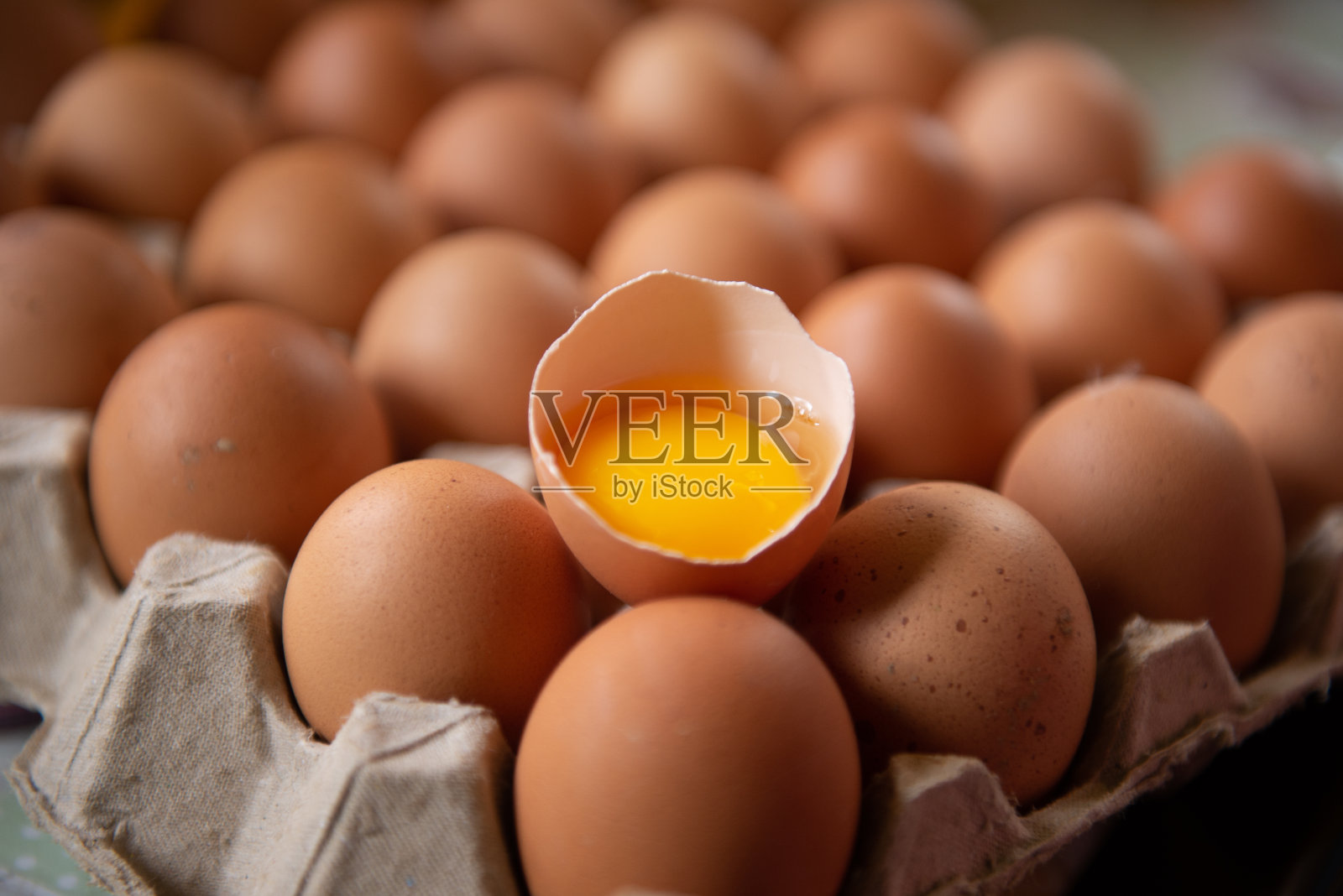 鸡蛋和半破的带蛋黄的鸡蛋，在Covid - 19病毒的情况下，鸡蛋是稀缺和昂贵的。照片摄影图片